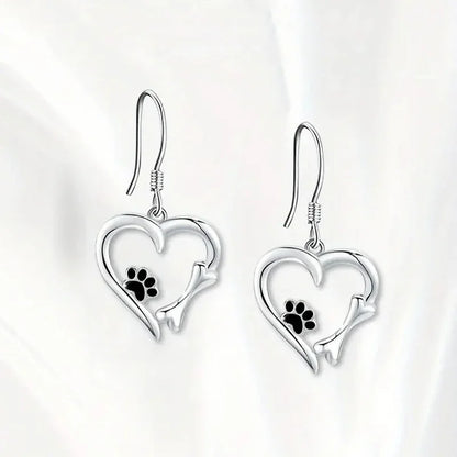 Pendientes colgantes de plata con diseño de corazón y huella de pata.