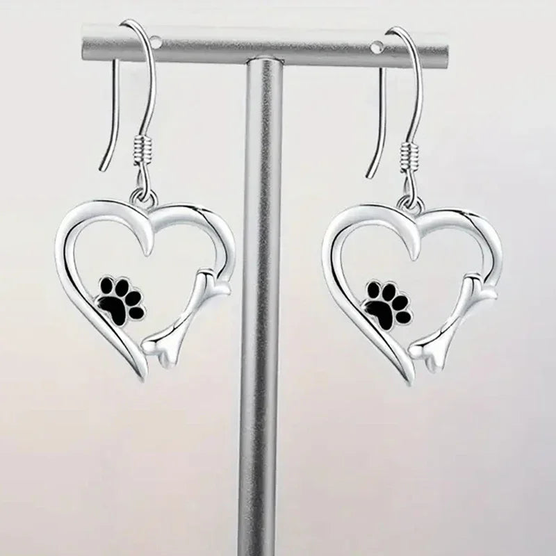 Pendientes colgantes de plata con diseño de corazón y huella de pata.